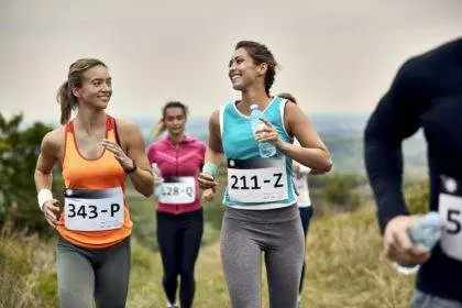 Young happy athletic women running a marathon in nature.